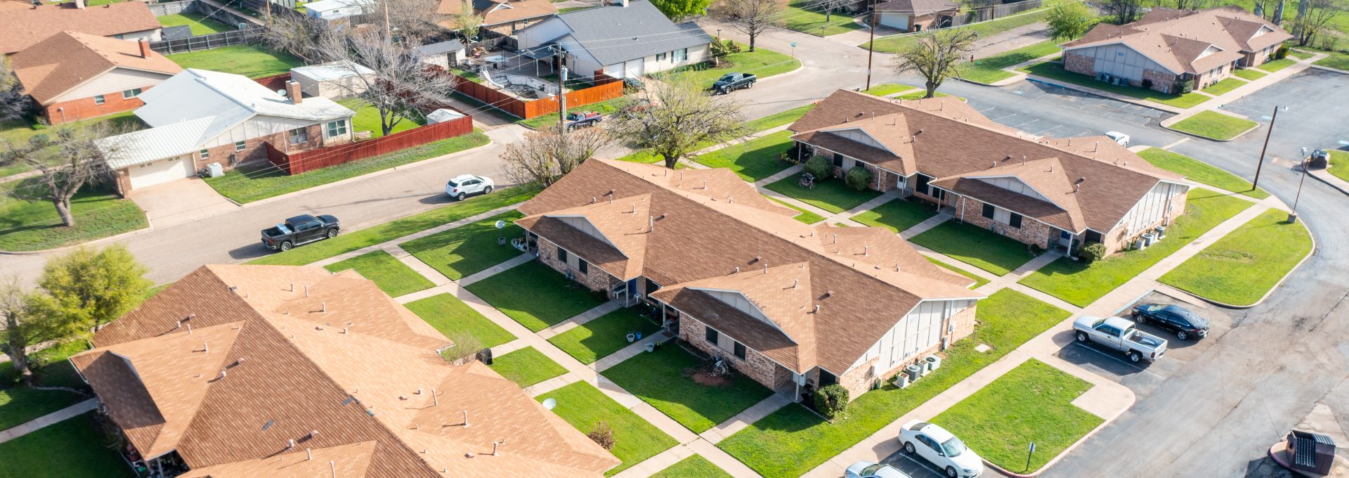 aerial view of a residential neighborhood with cars parked in front at The Sunscape Apartments