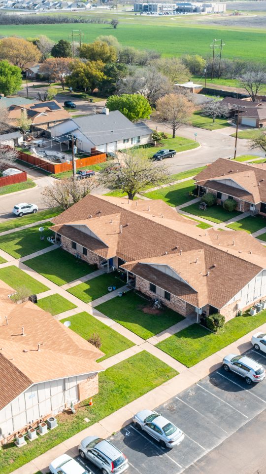 aerial view of a residential neighborhood with cars parked in front at The Sunscape Apartments