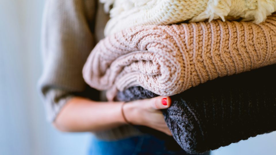 person holding knitted textiles